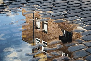 House reflected in a puddle of water