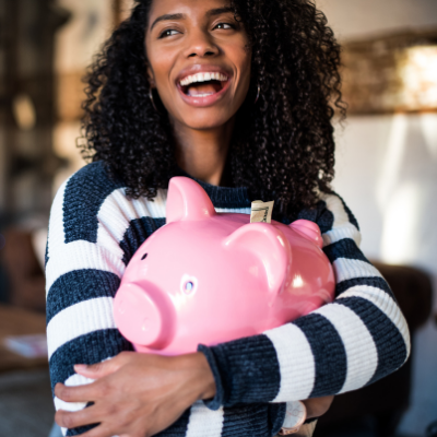 Woman holding a piggybank and laughing 